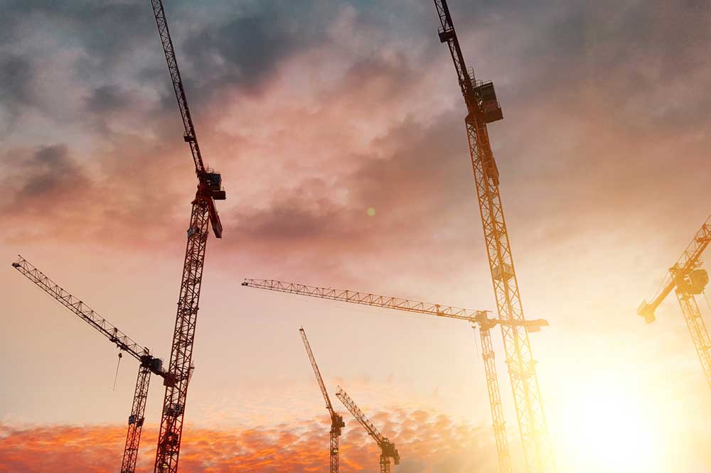 Byggkranar i solnedgång.