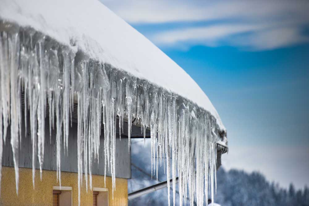 Snöskottning av tak som fått istappar.